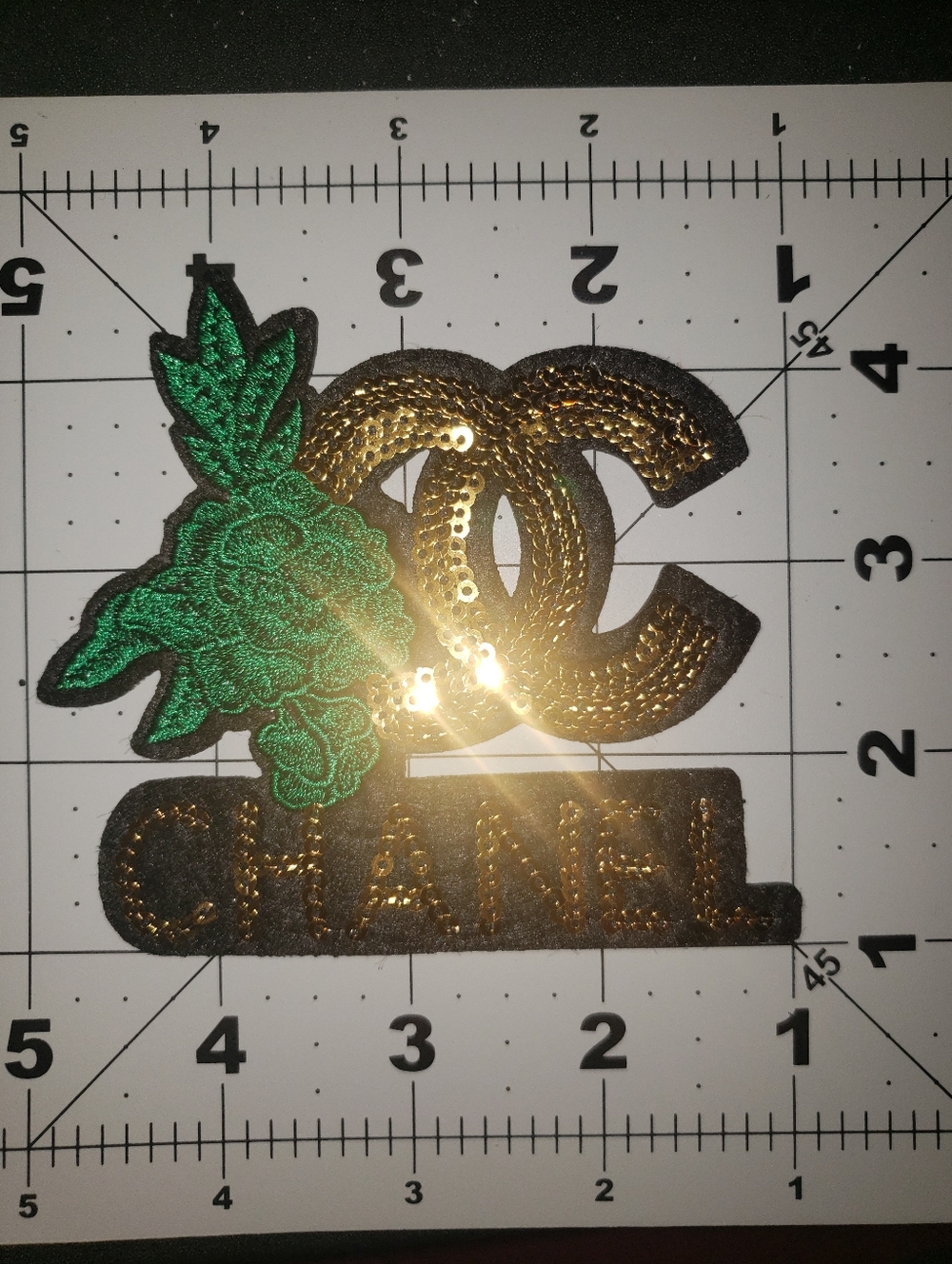 CHANEL Gold Sequin Logo Patch with Green Floral Embellishment